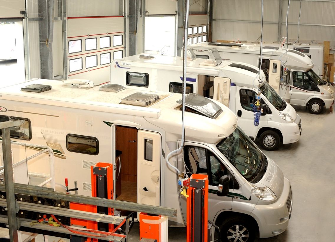 Überblick in Werkstatt mit drei Wohnmobilen